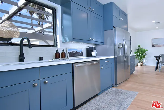 a kitchen with stainless steel appliances a sink refrigerator and cabinets