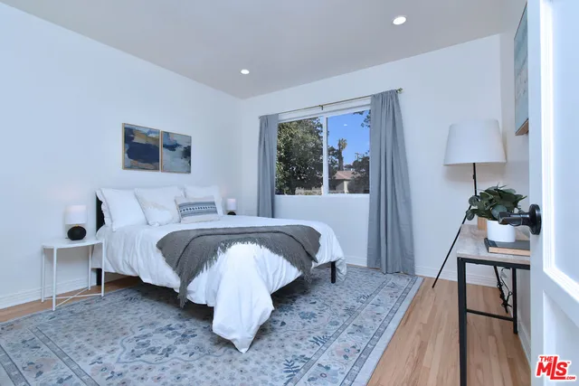 a bedroom with a bed and a flat tv screen on dresser