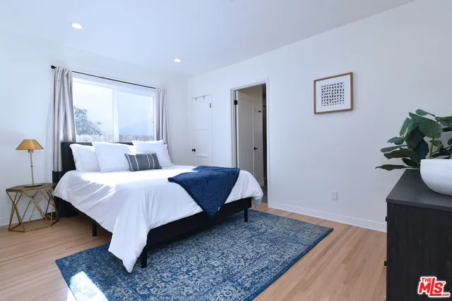 a bed room with a bed and a potted plant