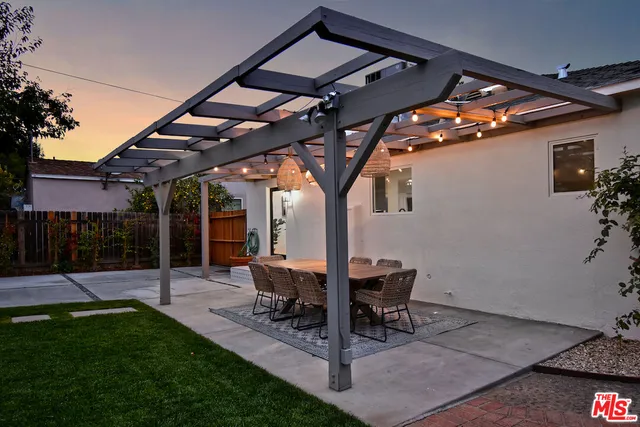 a view of a patio with table and chairs with wooden floor and fence