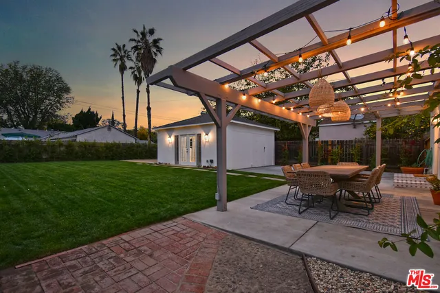 a backyard of a house with table and chairs