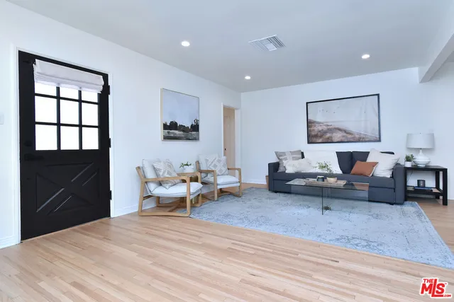 a living room with furniture and a dresser