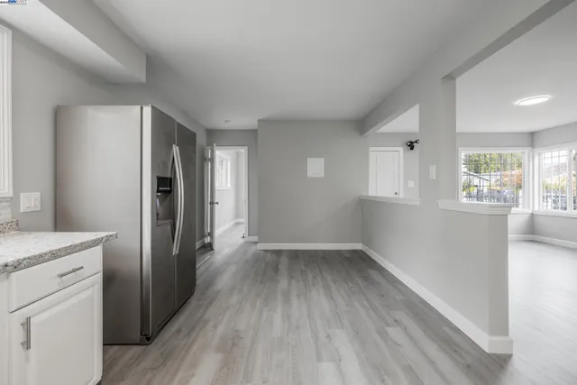 wooden floor in an empty room with a kitchen