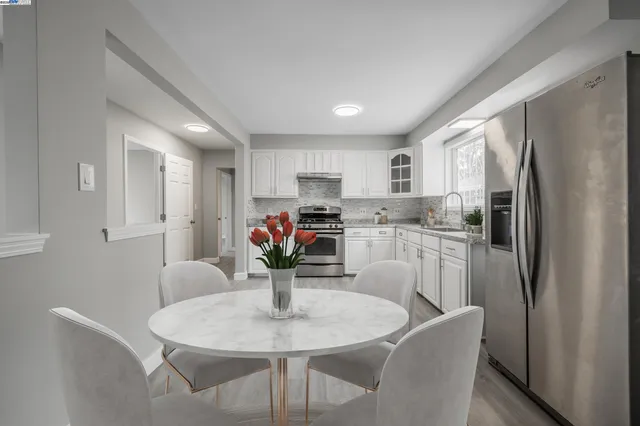 a kitchen with stainless steel appliances granite countertop a dining table chairs and granite counter tops