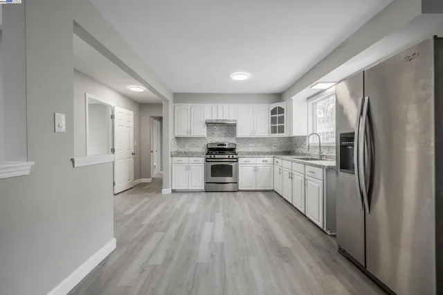 a kitchen with a refrigerator a sink and cabinets