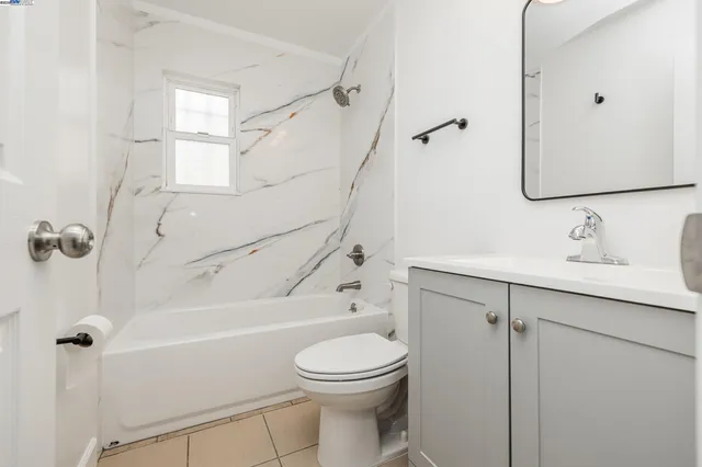 a bathroom with a toilet sink vanity and shower