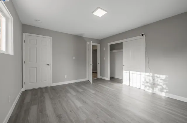 a view of empty room with wooden floor