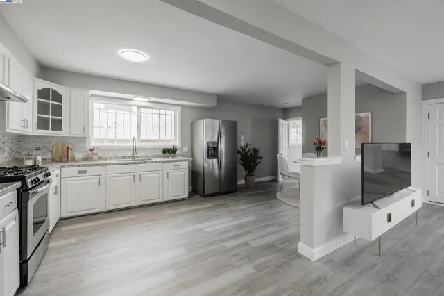 a kitchen with a sink cabinets stainless steel appliances and a window
