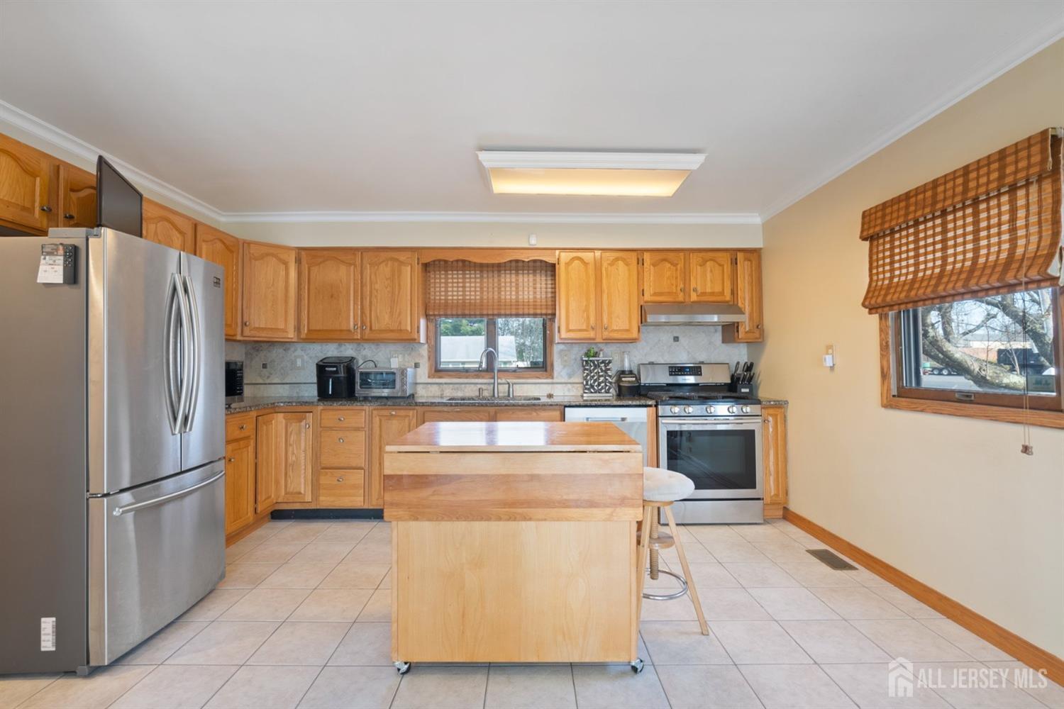 31 Villanova Road Old Bridge, NJ 08859 - Photo 10 of 29 a kitchen with stainless steel appliances a refrigerator a stove a sink a dining table and chairs