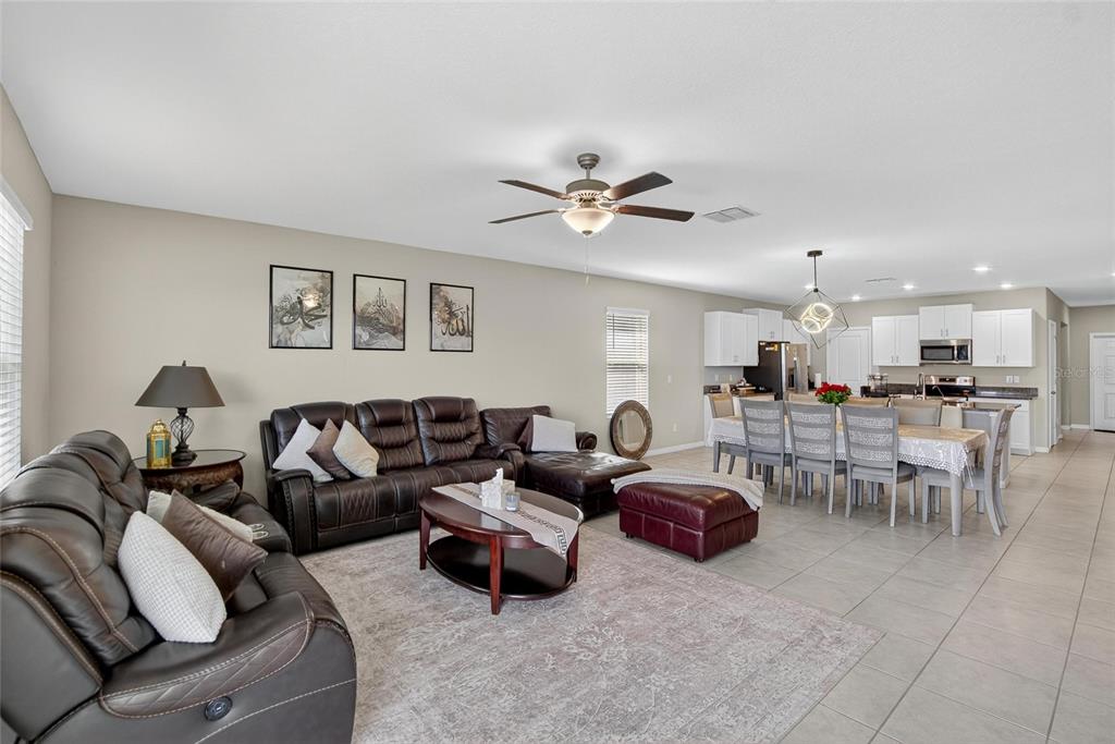 31783 Sun Kettle Loop Wesley Chapel, FL 33545 - Photo 17 of 73 a living room with furniture kitchen view and a chandelier
