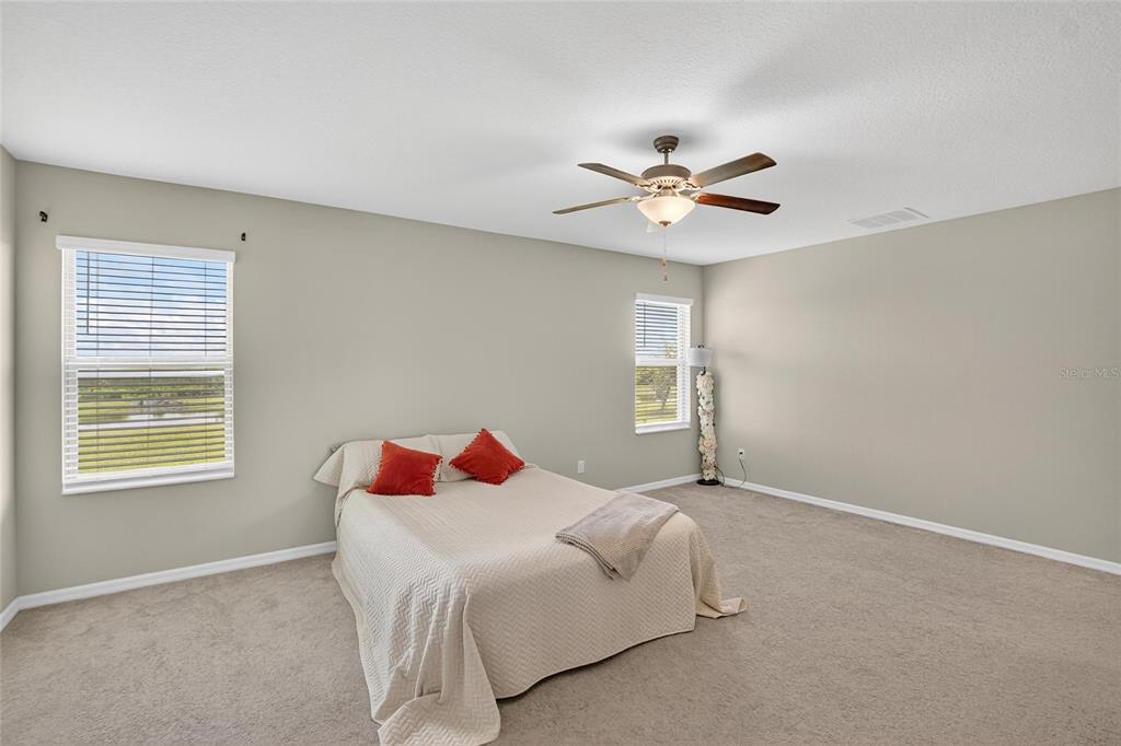 31783 Sun Kettle Loop Wesley Chapel, FL 33545 - Photo 24 of 73 a bedroom with a bed and a ceiling fan in it