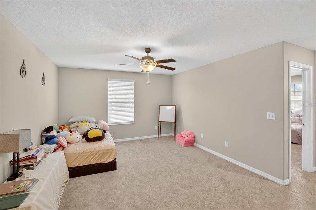 31783 Sun Kettle Loop Wesley Chapel, FL 33545 - Photo 33 of 73 a bedroom with a bed and a chandelier
