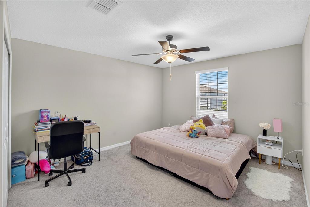31783 Sun Kettle Loop Wesley Chapel, FL 33545 - Photo 36 of 73 a bedroom with a bed and a chandelier