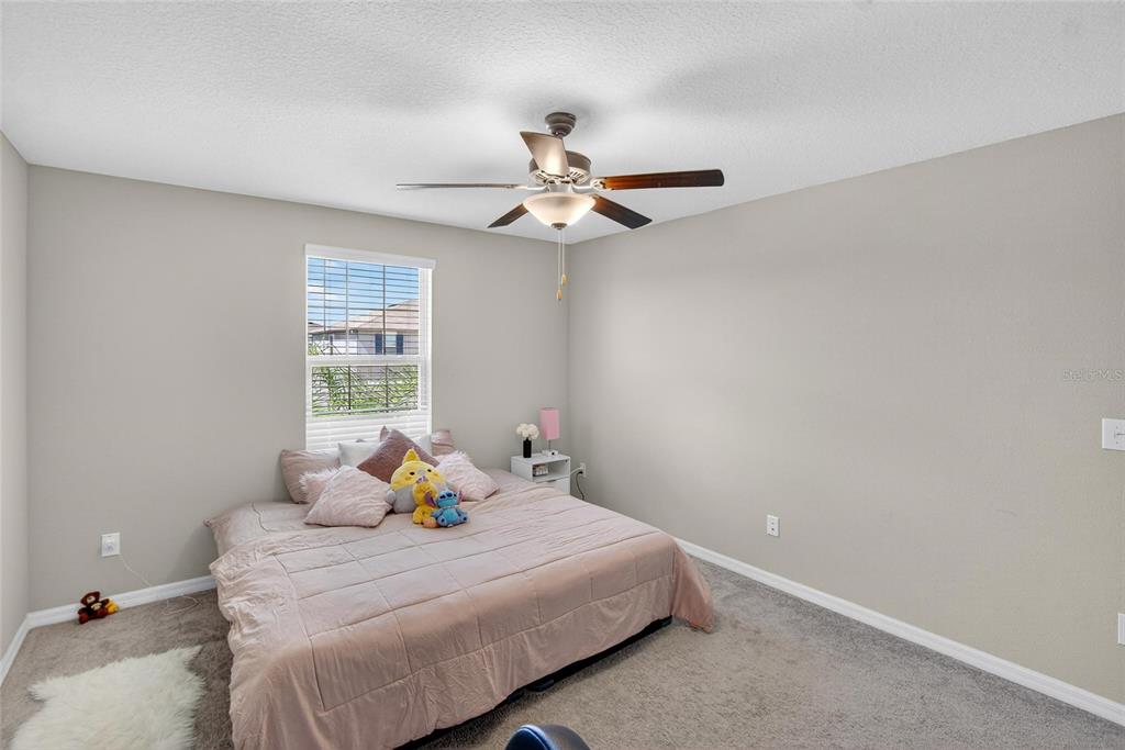 31783 Sun Kettle Loop Wesley Chapel, FL 33545 - Photo 38 of 73 a bedroom with a bed and a ceiling fan