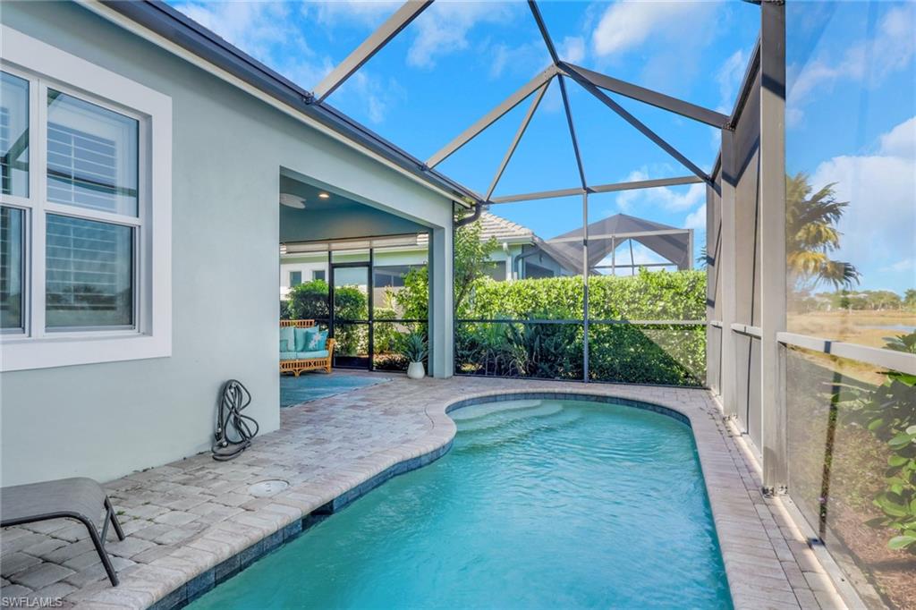 6809 Bequia Way Naples, FL 34113 - Photo 32 of 49 Outdoor pool with a patio, a lanai, and a sunroom
