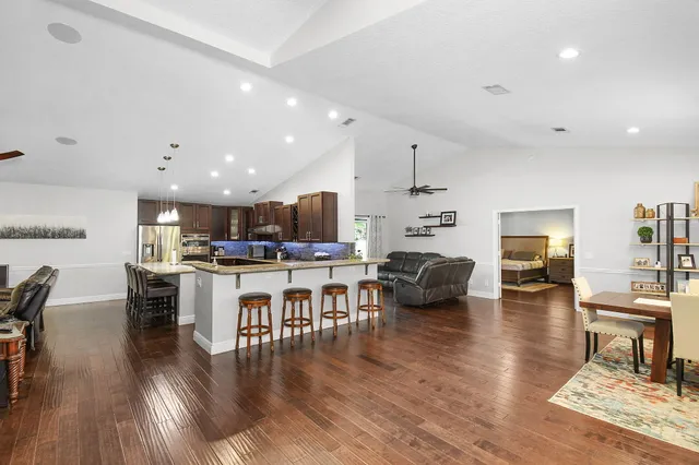 a kitchen with kitchen island a large counter top stainless steel appliances and cabinets