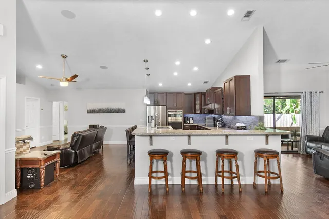 a living room with lots of furniture and kitchen view