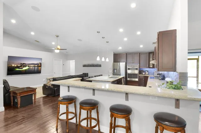 a kitchen with granite countertop a sink stainless steel appliances and cabinets
