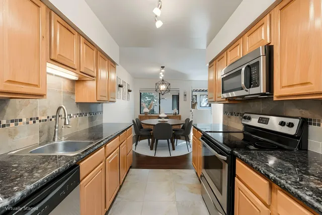 a kitchen with stainless steel appliances granite countertop a stove a sink and a microwave