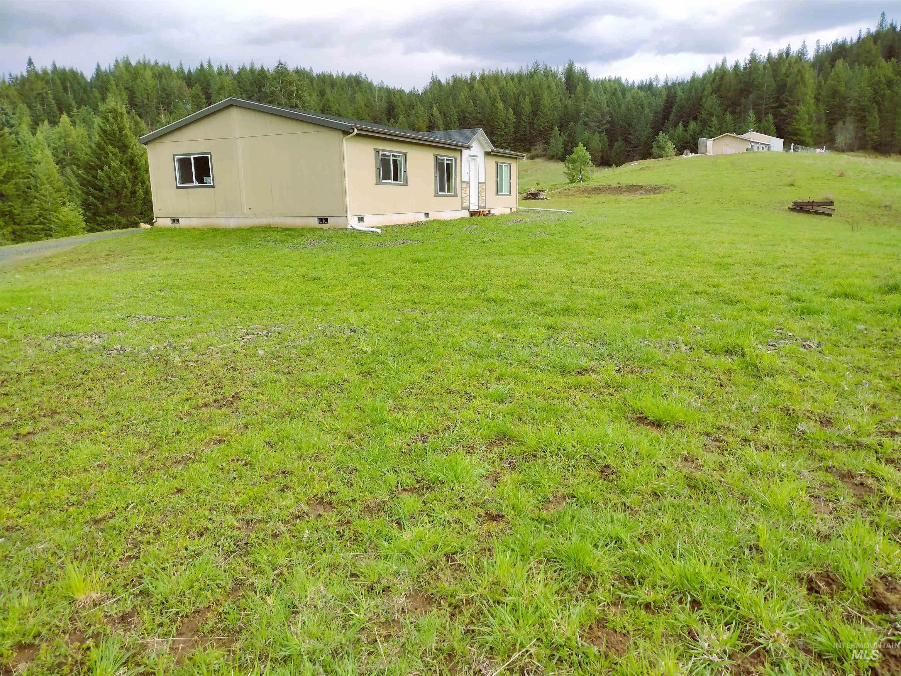 142 Shenandoah Third Street Kamiah, ID 83536 - Photo 1 of 50 Back of property with a wooded view, a yard, and crawl space