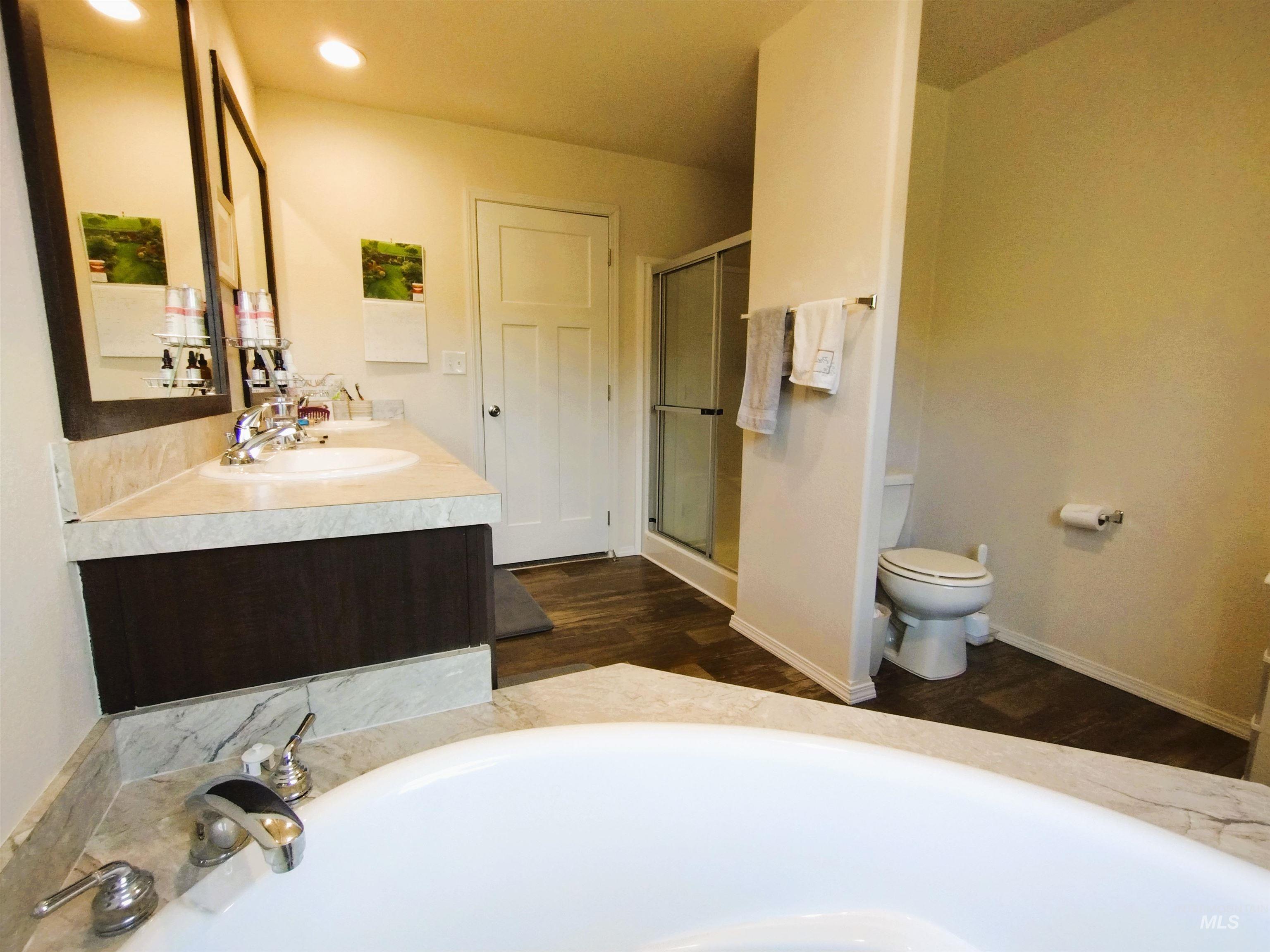 142 Shenandoah Third Street Kamiah, ID 83536 - Photo 35 of 50 Full bath featuring double vanity, a shower stall, a garden tub, dark wood-type flooring, and recessed lighting