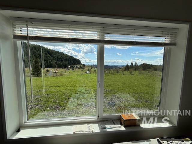 142 Shenandoah Third Street Kamiah, ID 83536 - Photo 43 of 50 Double-paned window framing a scenic landscape with rolling green fields and distant evergreen forests
