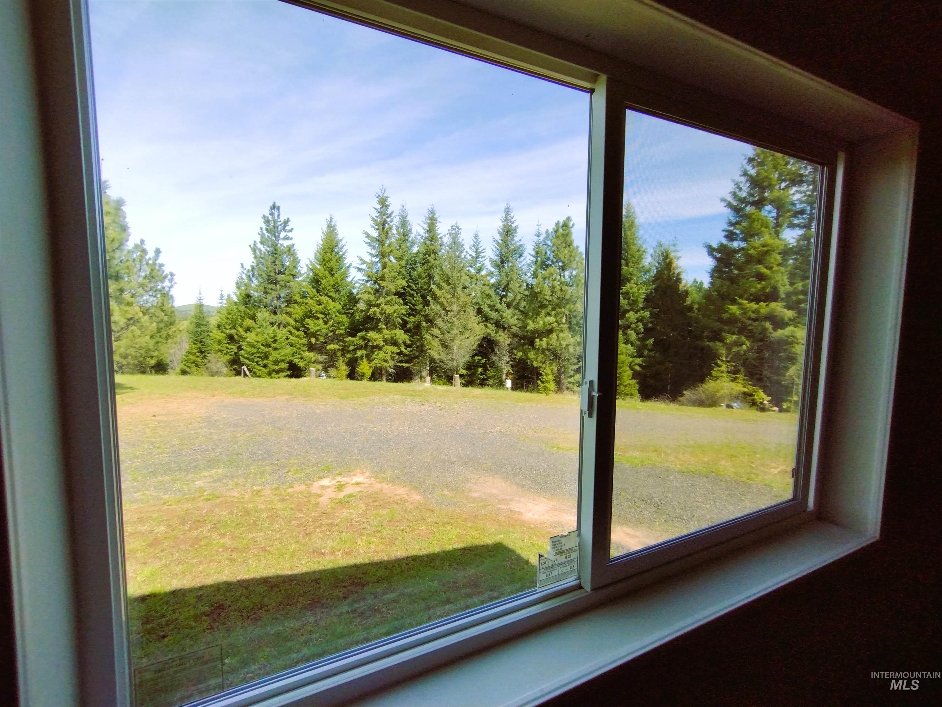 142 Shenandoah Third Street Kamiah, ID 83536 - Photo 47 of 50 Sliding window offering expansive outdoor views of evergreen trees and a partially treed landscape