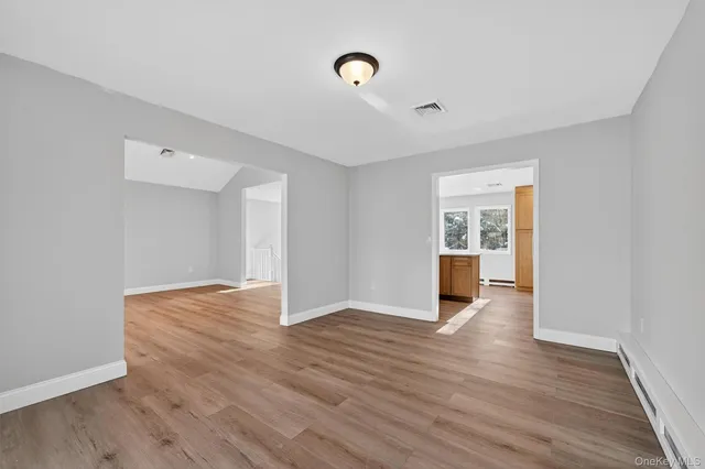 a view of an empty room with wooden floor