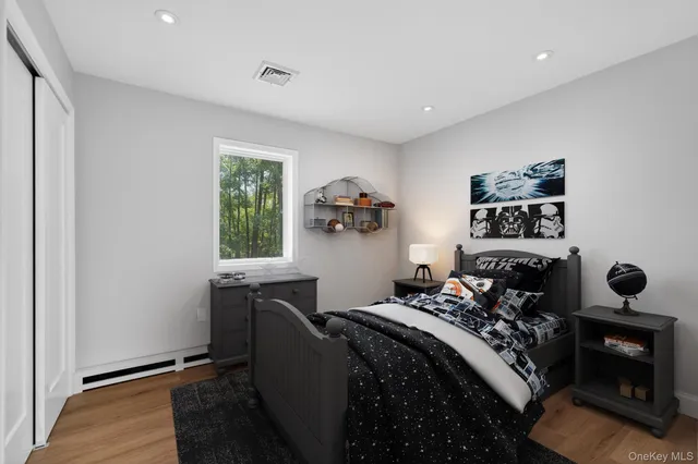 a bedroom with a bed and wooden floor