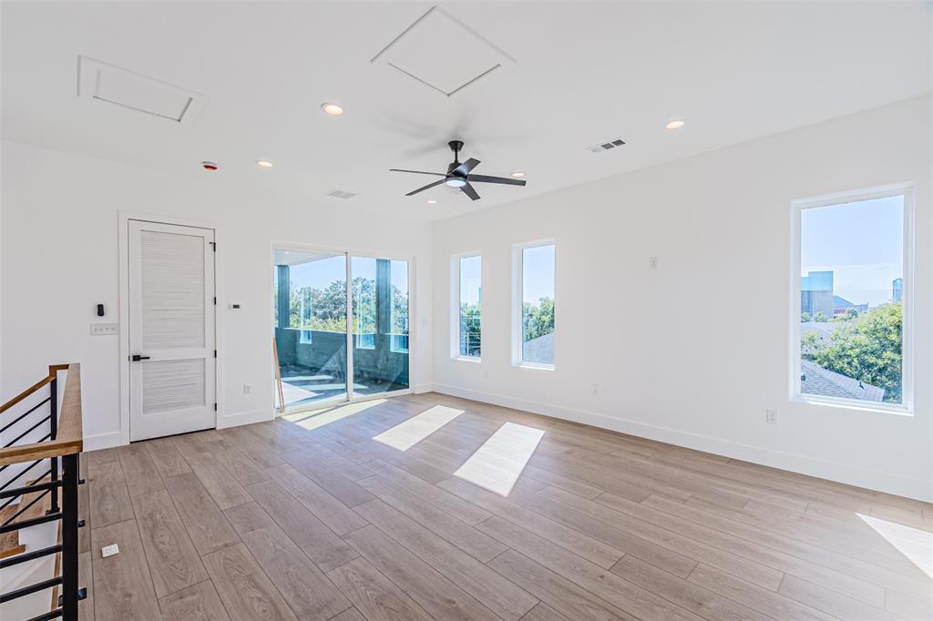 4309 Sylvester Street Dallas, TX 75219 - Photo 29 of 39 a view of an empty room with a window and wooden floor