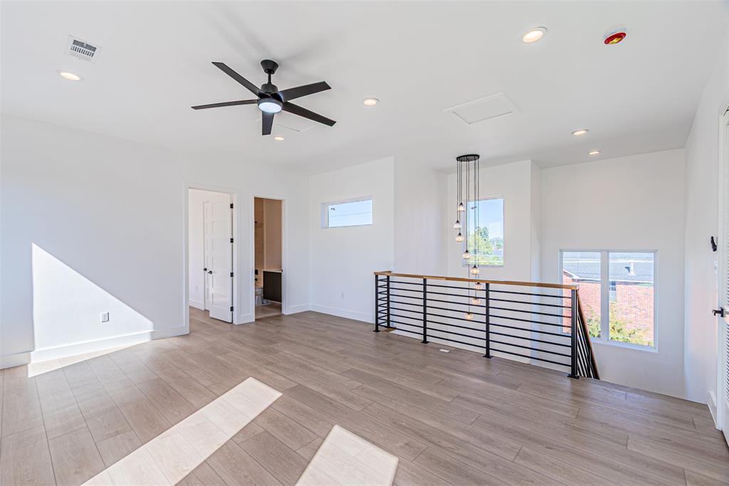 4309 Sylvester Street Dallas, TX 75219 - Photo 32 of 39 a view of an empty room with a window and wooden floor