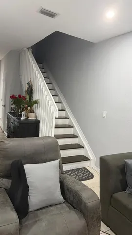 a living room with furniture and stairs