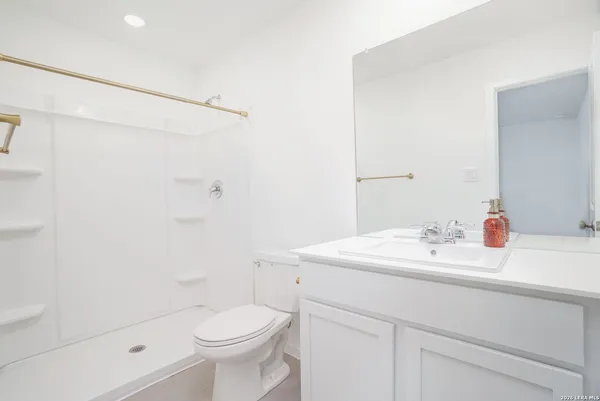 a bathroom with a sink a toilet and shower