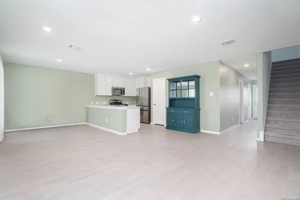 a view of a kitchen with a sink and dishwasher a refrigerator with wooden floor