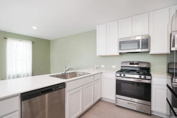 a kitchen with a sink stove and microwave