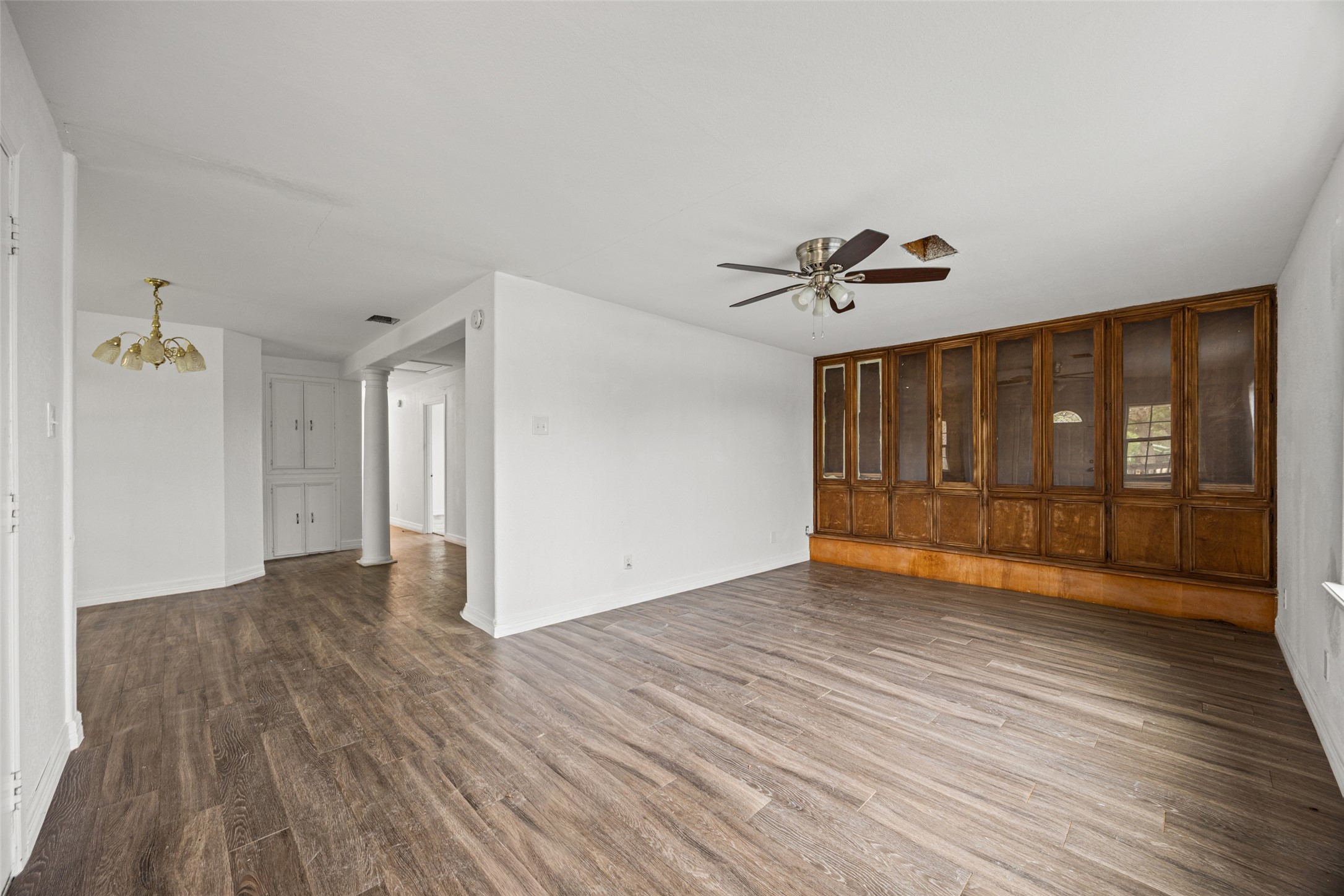 11622 Doyle Overton Road Austin, TX 78719 - Photo 2 of 20 a view of an empty room with wooden floor and a ceiling fan