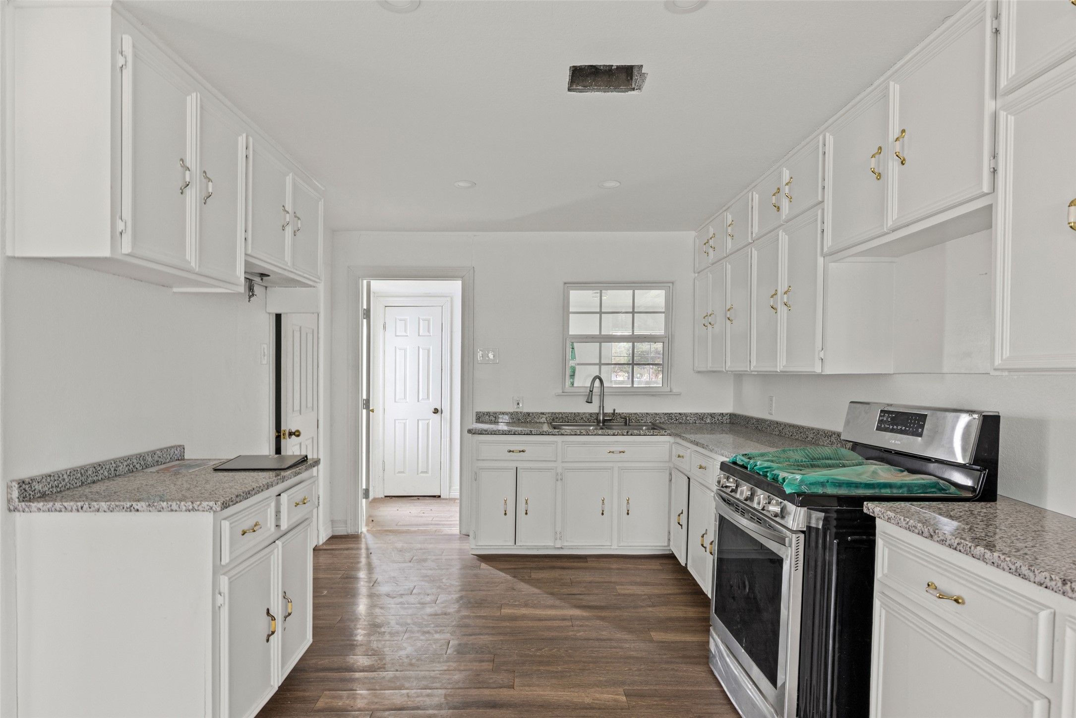 11622 Doyle Overton Road Austin, TX 78719 - Photo 3 of 20 a kitchen with granite countertop a sink stove and cabinets