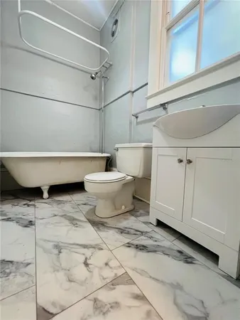 a bathroom with a toilet a sink and bathtub