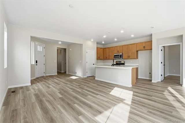 a view of kitchen with wooden floor and electronic appliances