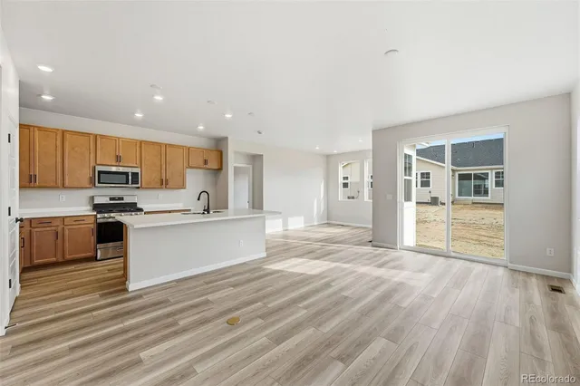 a large kitchen with kitchen island a large counter top stainless steel appliances and cabinets