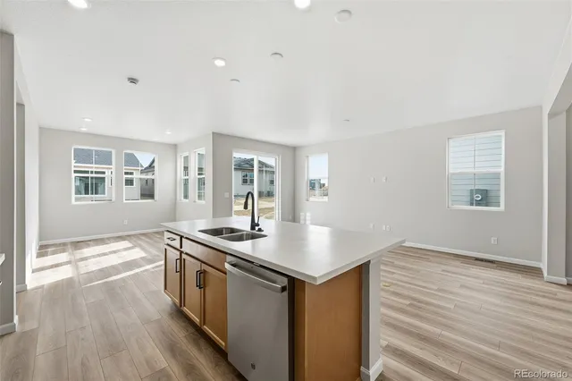 a kitchen that has a sink a stove and wooden floor