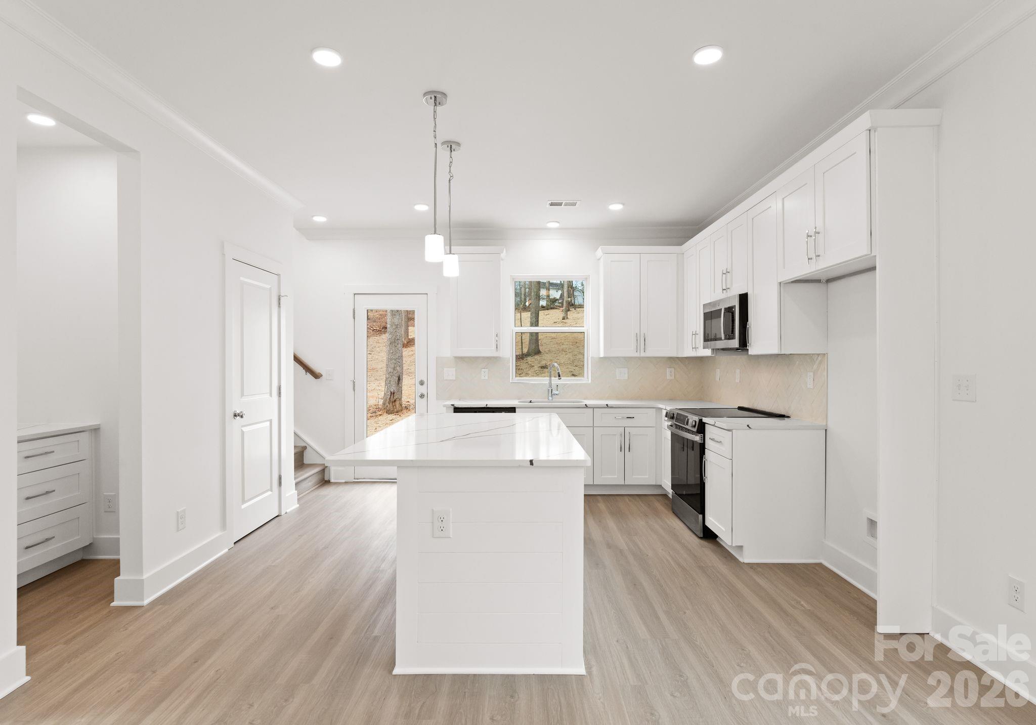 1906 Rucker Road Shelby, NC 28152 - Photo 8 of 21 a large white kitchen with lots of counter space wooden floor and appliances