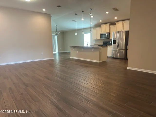 a view of a kitchen with a wooden floor and a window