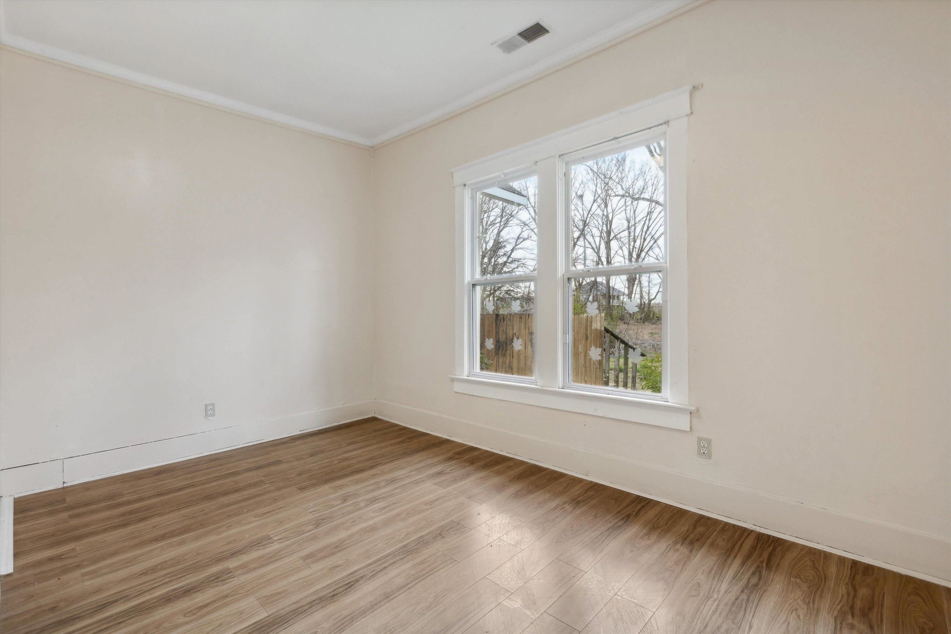8457 East Kerrville Rosemark Road Millington, TN 38053 - Photo 20 of 32 Empty room featuring wood finished floors and crown molding