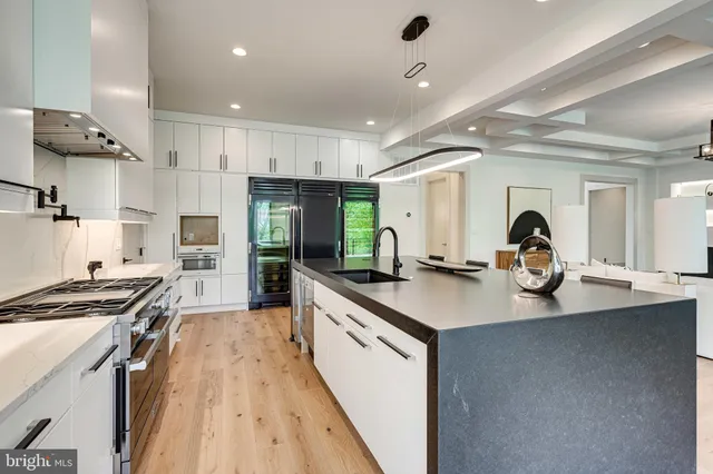 a kitchen with stainless steel appliances kitchen island granite countertop a table and chairs in it