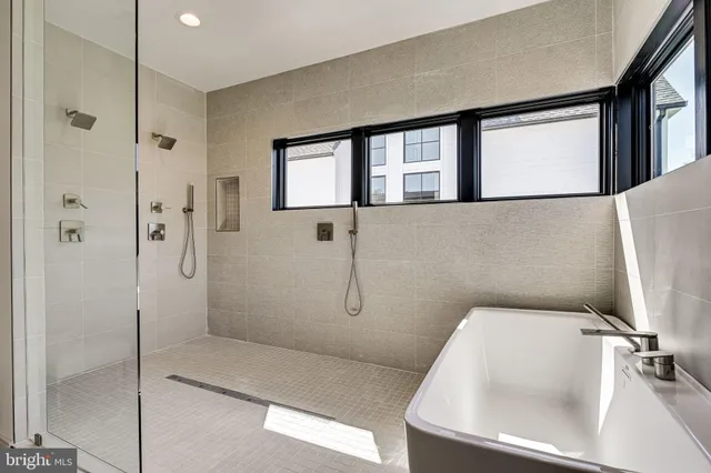 a white bath tub sitting in a bathroom next to a window