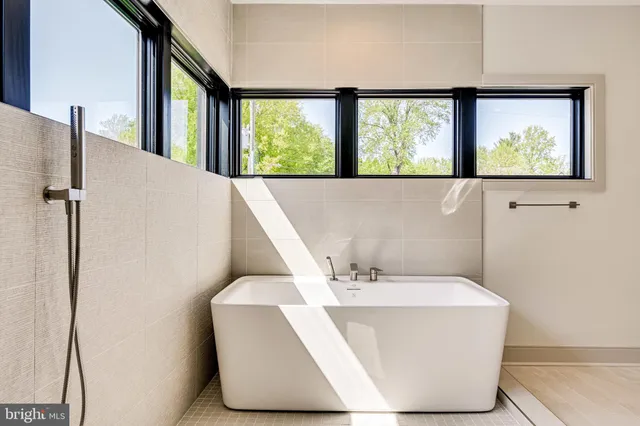 a hallway with view of the bathroom and mirror