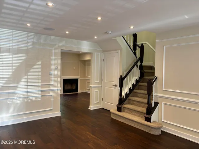 a view of a livingroom with wooden floor and staircase