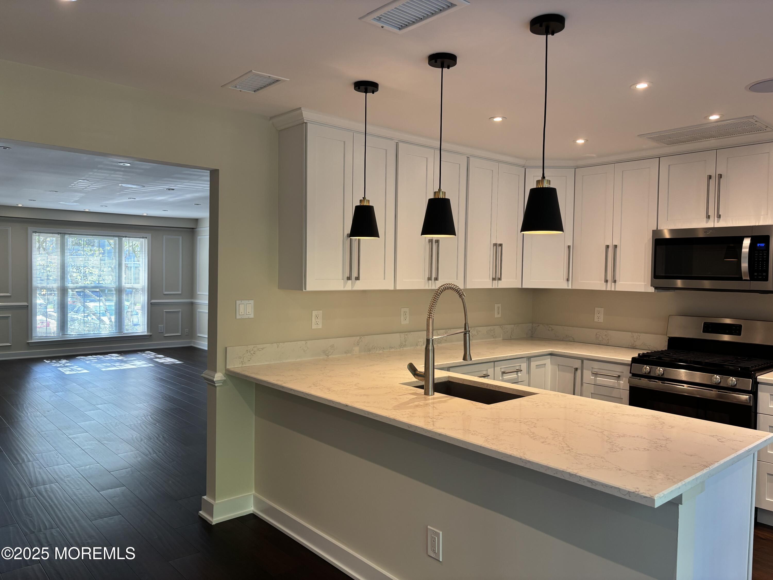 276 Sugar Maple Court Howell, NJ 07731 - Photo 7 of 34 a kitchen with stainless steel appliances granite countertop a sink a stove and a wooden floor