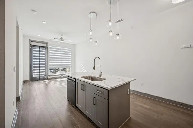 a kitchen with a sink a counter space and wooden floor
